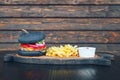 Black burger with French fries and sauce on a wooden board Royalty Free Stock Photo