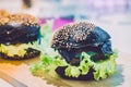 Black burger on wooden cutting board, in the kitchen close-up, selective focus Royalty Free Stock Photo