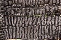 Black burnt wall of house of wooden planks with embossed texture. background for copy space. concept of loss of real estate or Royalty Free Stock Photo