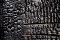 Black burnt wall of house of wooden planks with embossed texture. damage to the building from fire without the possibility of Royalty Free Stock Photo