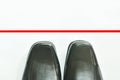 Black business leather shoe with red line to transcend on white background