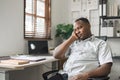 Black business man is stressed, bored, and overthinking from working on a laptop at the modern office Royalty Free Stock Photo