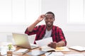 Black businessman in casual office, workplace with laptop and paperwork Royalty Free Stock Photo