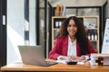 Black Businesswoman Sitting at Her Desk Working on a Laptop Computer. Smiling Successful African American Woman working Royalty Free Stock Photo