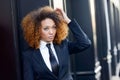 Black businesswoman wearing suit and tie in urban background Royalty Free Stock Photo