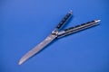 Black butterfly knife on blue ground Royalty Free Stock Photo