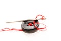 Black button, needle with red thread close up macro shot isolated Royalty Free Stock Photo