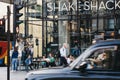 Black cab driving past Shake Shack in Victoria station, London, UK, motion blur Royalty Free Stock Photo