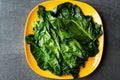 Black Cabbage Leaves / Organic Green Lacinato Kale on Yellow Plate with Grey Granit Surface Royalty Free Stock Photo