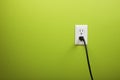 Black cable plugged in a white electric outlet Royalty Free Stock Photo