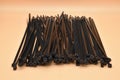 Black cable ties isolated on orange background. Plastic Tie Wraps Royalty Free Stock Photo