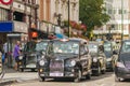 Black cabs waiting for green segnal at a traffic light near Leicester Square in London Royalty Free Stock Photo