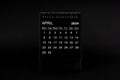 Black Calendar for April 2024. Desktop calendar on a black background