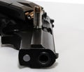 A black 40 caliber pistol on it`s side with a loaded pistol magazine on top of it with a single 40 caliber bullet Royalty Free Stock Photo