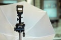 Black camera tripod with studio lightning equipment on blurred background, white umbrella for professional photo and video shootin Royalty Free Stock Photo