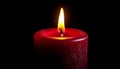 A black candle flickering in a dark room Royalty Free Stock Photo