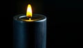 A black candle flickering in a dark room Royalty Free Stock Photo