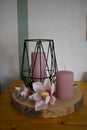 Black candlestick with a pink candle on a wooden table