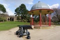 Black Cannon in Front of a Wrought Iron Bandstand. Royalty Free Stock Photo