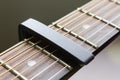 Black Capo on Acoustic Guitar String and Fingerboard Royalty Free Stock Photo