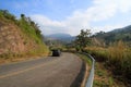 Black car on asphalt road go down and up to hill along with mountains and clouds blue sky background at Phu Lanka Forest Park Royalty Free Stock Photo