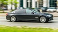 Black car BMW 7 Series F01 is driving on asphalt road on high speed in the city Moscow