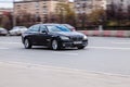 Black car BMW 7 Series F01 is driving on asphalt road on high speed in the city Moscow