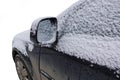 Black car covered with snow in winter Royalty Free Stock Photo