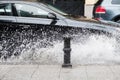 Black car crossing a road and splashing rain water Royalty Free Stock Photo