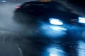 Black car driving through heavy night rain and spraying water Royalty Free Stock Photo