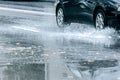 Black car driving through rain puddle with splashing water from Royalty Free Stock Photo