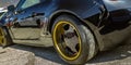 Black car with gold wheel rim and black spokes Royalty Free Stock Photo