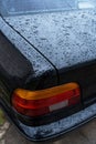 black car in the yard in water drops after rain with Royalty Free Stock Photo