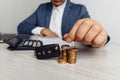 Black car key with contract on wooden table and man with money. Concept business finance and insurance, savings plans Royalty Free Stock Photo