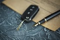Black car key and money on a signed contract of car sale. Royalty Free Stock Photo