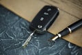 Black car key and money on a signed contract of car sale. Royalty Free Stock Photo