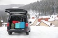 Car with luggage in trunk on snowy road. Winter vacation Royalty Free Stock Photo