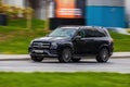 Black car Mercedes-Benz GLS 580 4MATIC X167 on the city road. Premium SUV fast driving on road in the city with blurred background Royalty Free Stock Photo