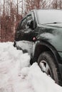 black car parked in snowdrift. Auto covered in snow. Wheel stuck in the deep snow Royalty Free Stock Photo