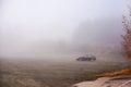 Black car parked on top of a mountain during heavy fog Royalty Free Stock Photo