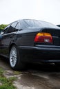 black car in the yard in water drops after rain with Royalty Free Stock Photo