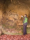 Black carbon paint of human hunting on sandstone wall, copy of prehistoric picture. Abstract children art in cave. Man at painting