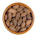 Black cardamom pods, dried large cardamom fruits, in a wooden bowl Royalty Free Stock Photo