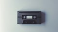 Black cassette tape on a light background, representing simplicity and retro music. Concept of vintage, minimalist