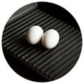 Black cast heavy iron grill pan in two organic white eggs on modern oak kitchen countertop