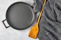 Black cast iron empty frying pan, wooden spatula and gray kitche Royalty Free Stock Photo