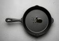 Black cast iron skillet with a loop handle and spouted sides on a light Royalty Free Stock Photo