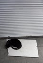 a black cat laying on the ground next to a white board Royalty Free Stock Photo