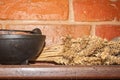 Black cauldron with an armful of wheat on a wooden shelf Royalty Free Stock Photo