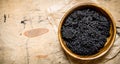 Black caviar in a bowl. On wooden table. Royalty Free Stock Photo